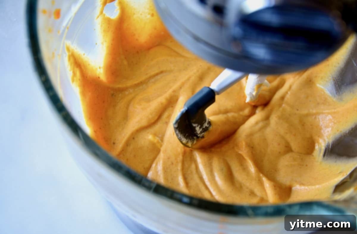 Pumpkin cheesecake batter in stand mixer