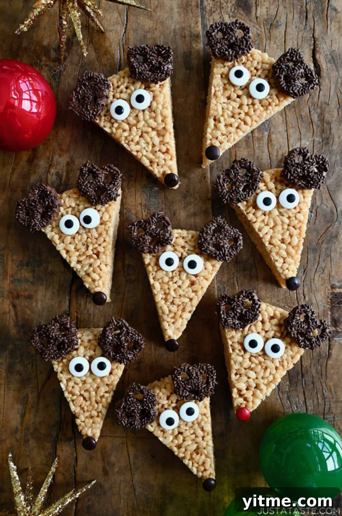 Triangles of festive Reindeer Rice Krispie Treats featuring chocolate-covered ears, candy eyes, and M&M noses.