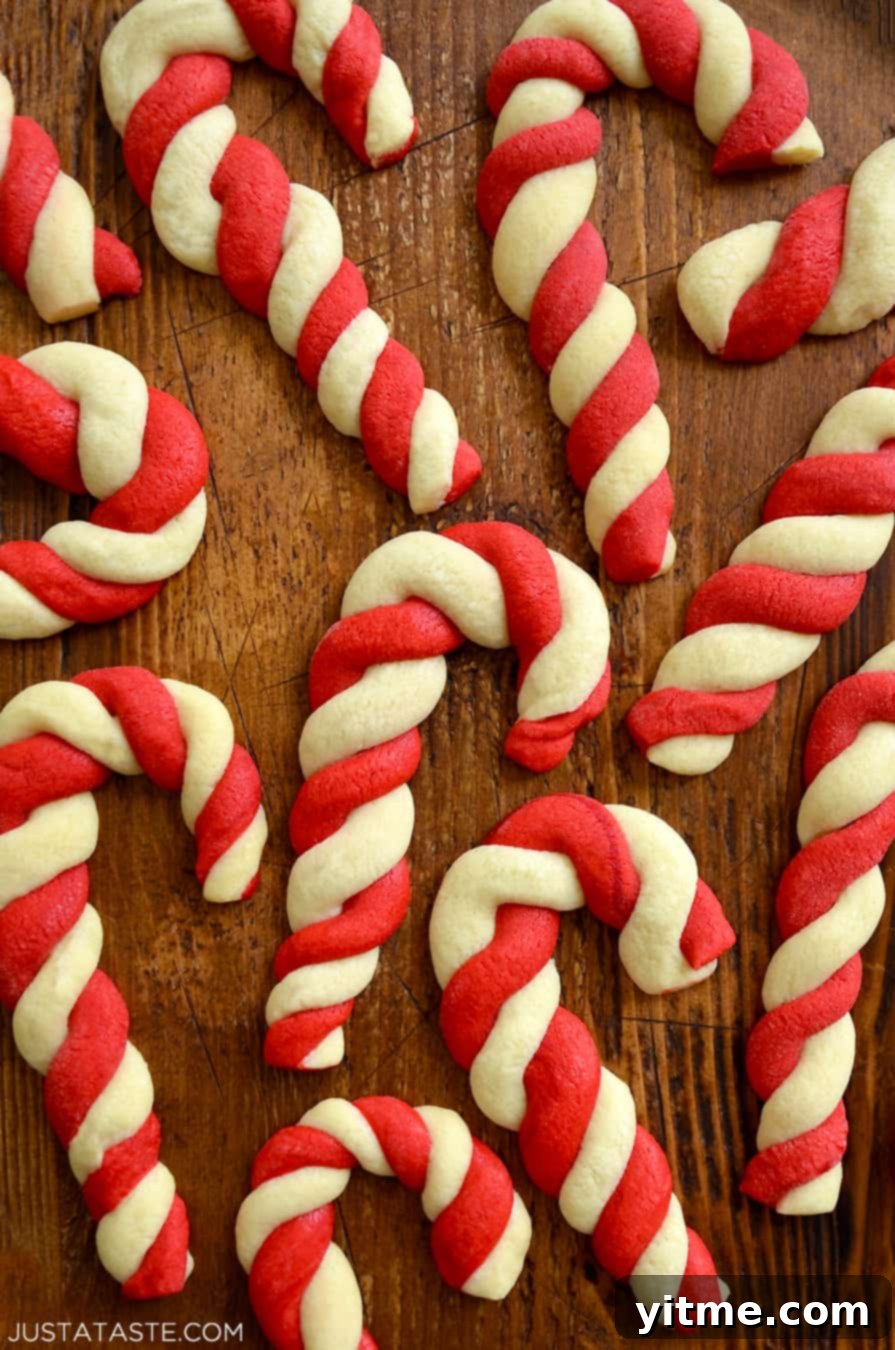 Festive candy cane cookies elegantly displayed on a dark surface.