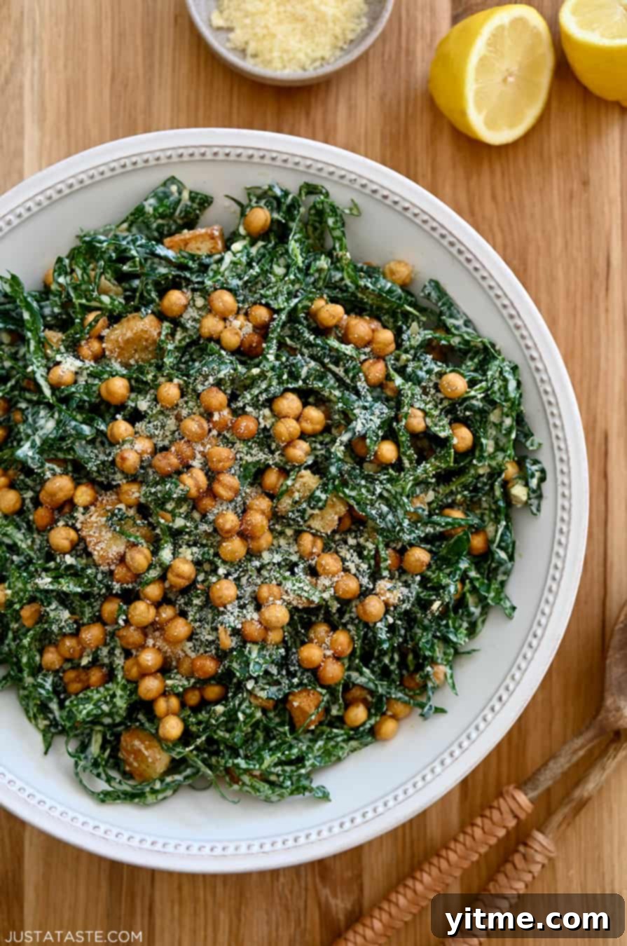 A top-down view of a white salad bowl with kale and chickpeas