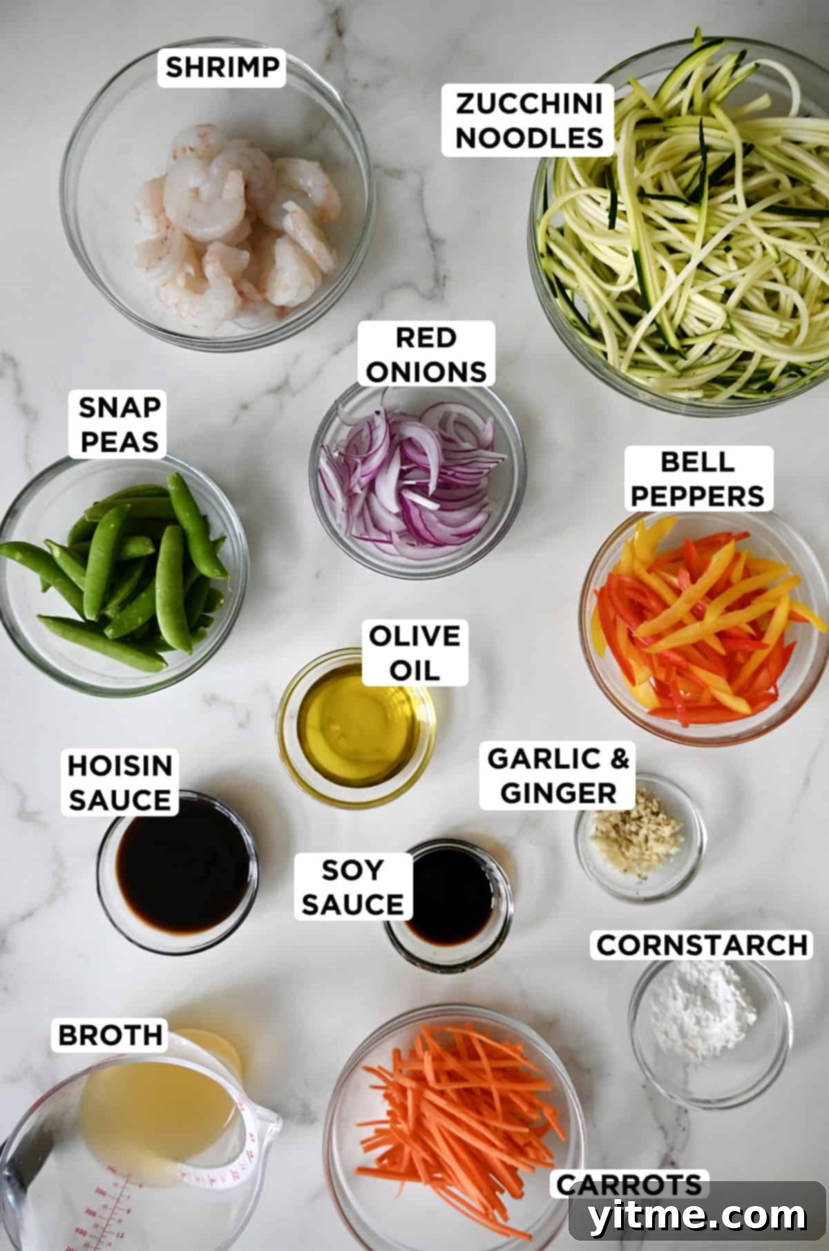 Ingredients for zucchini noodle stir-fry with shrimp in small glass bowls.