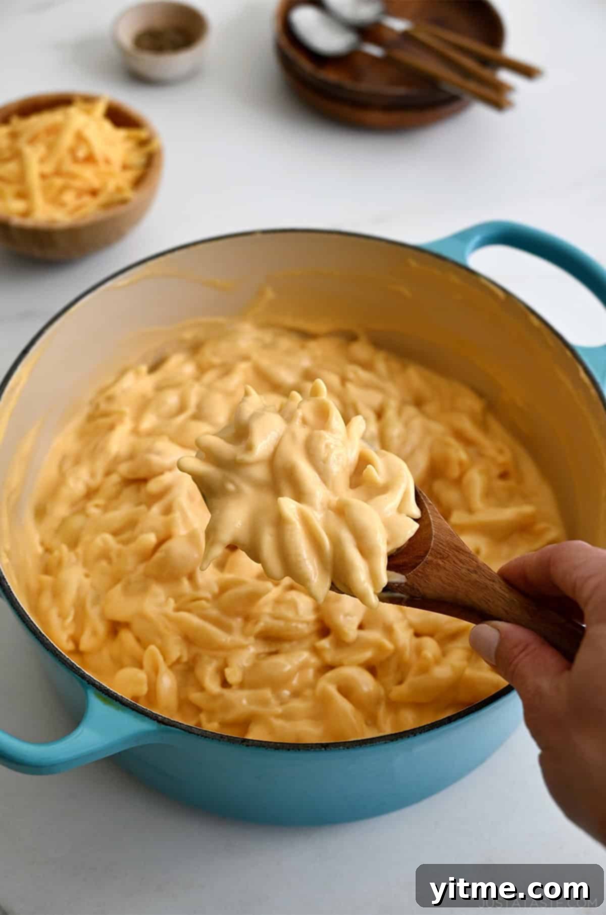 Creamy stovetop mac and cheese being scooped from a pot
