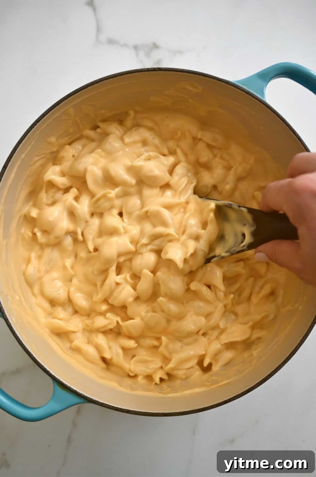Stovetop mac and cheese being stirred