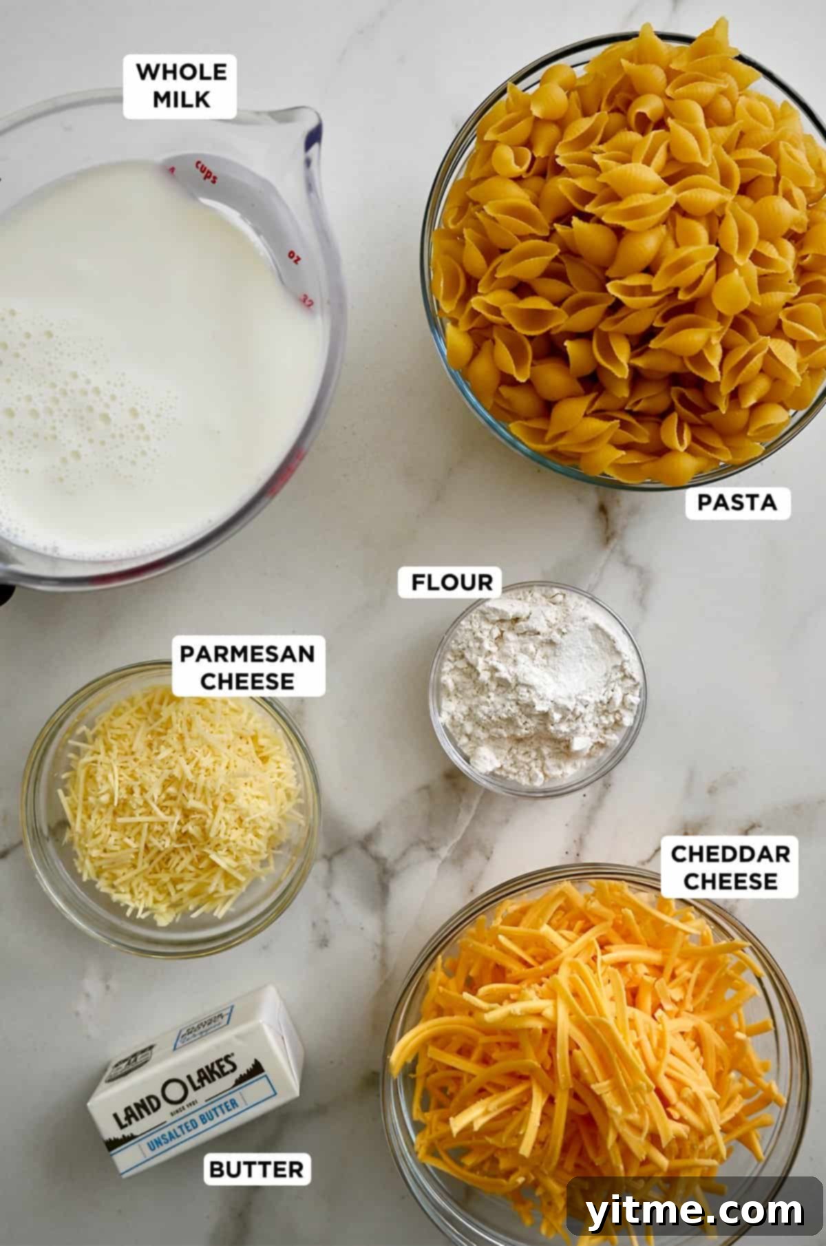 Ingredients for stovetop mac and cheese: pasta, milk, butter, flour, cheddar, and Parmesan