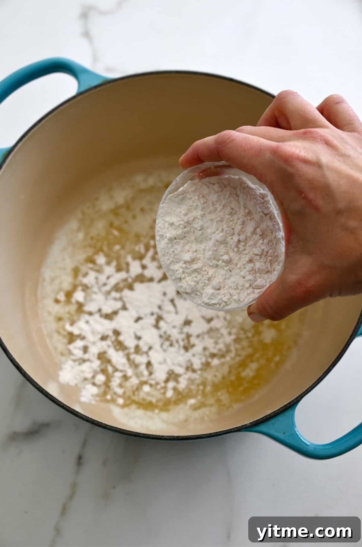 A roux in a stockpot being whisked