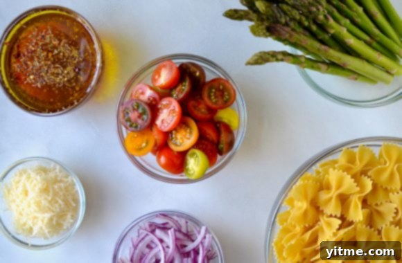 Asparagus Pasta Salad with Zesty Italian Vinaigrette 3 Various sizes of clear bowls containing Italian dressing, cherry tomatoes, asparagus, bow tie pasta, sliced red onion and Parmesan cheese
