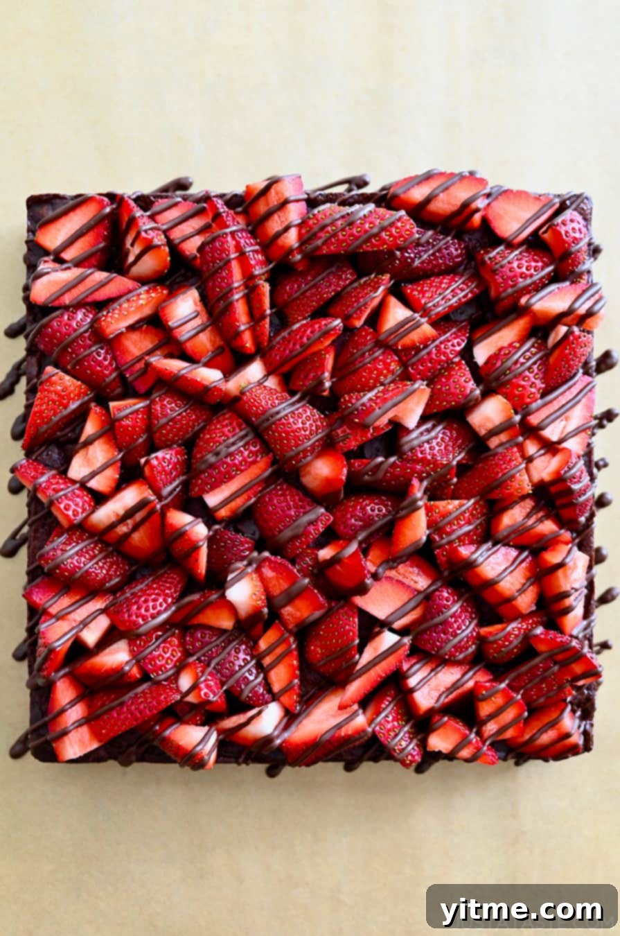 A top-down view of Chocolate-Covered Strawberry Brownies drizzled with chocolate