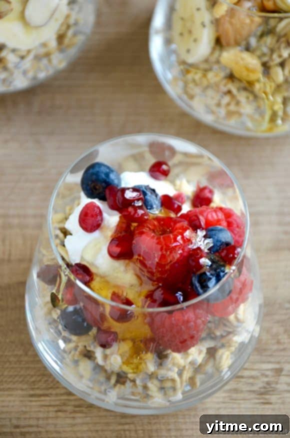 Glass of overnight oats topped with yogurt, raspberries, and blueberries