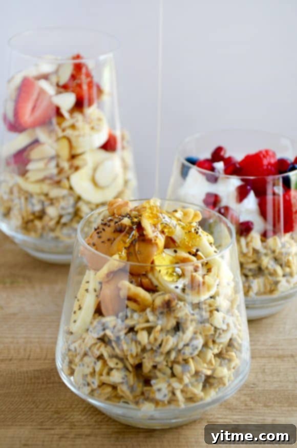 A clear glass containing oats topped with bananas, peanut butter and chia seeds with honey being drizzled on top