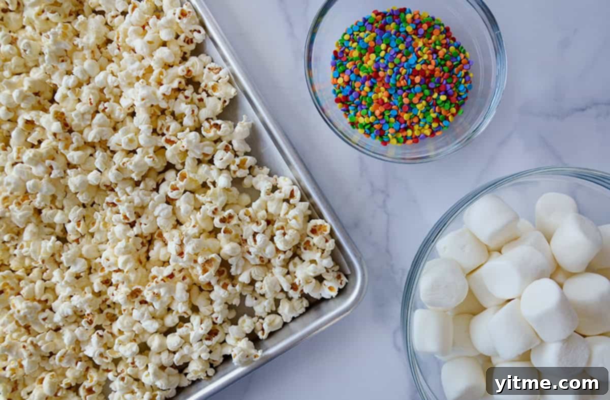 Ingredients to make marshmallow popcorn: fluffy popcorn, marshmallows and sprinkles.