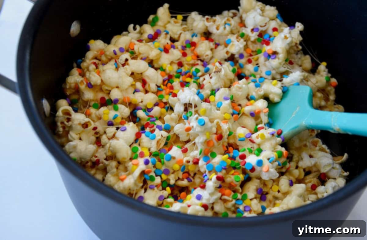 Popcorn coated in melted marshmallows and butter in a pan.