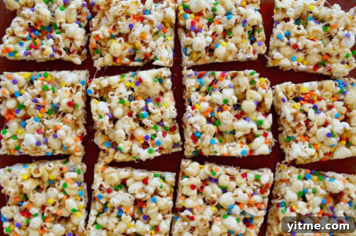Marshmallow popcorn with rainbow sprinkles cut into squares.