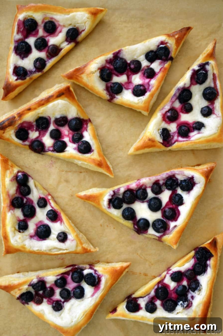 Top-down view of Blueberry Cream Cheese Pastries on brown parchment paper.