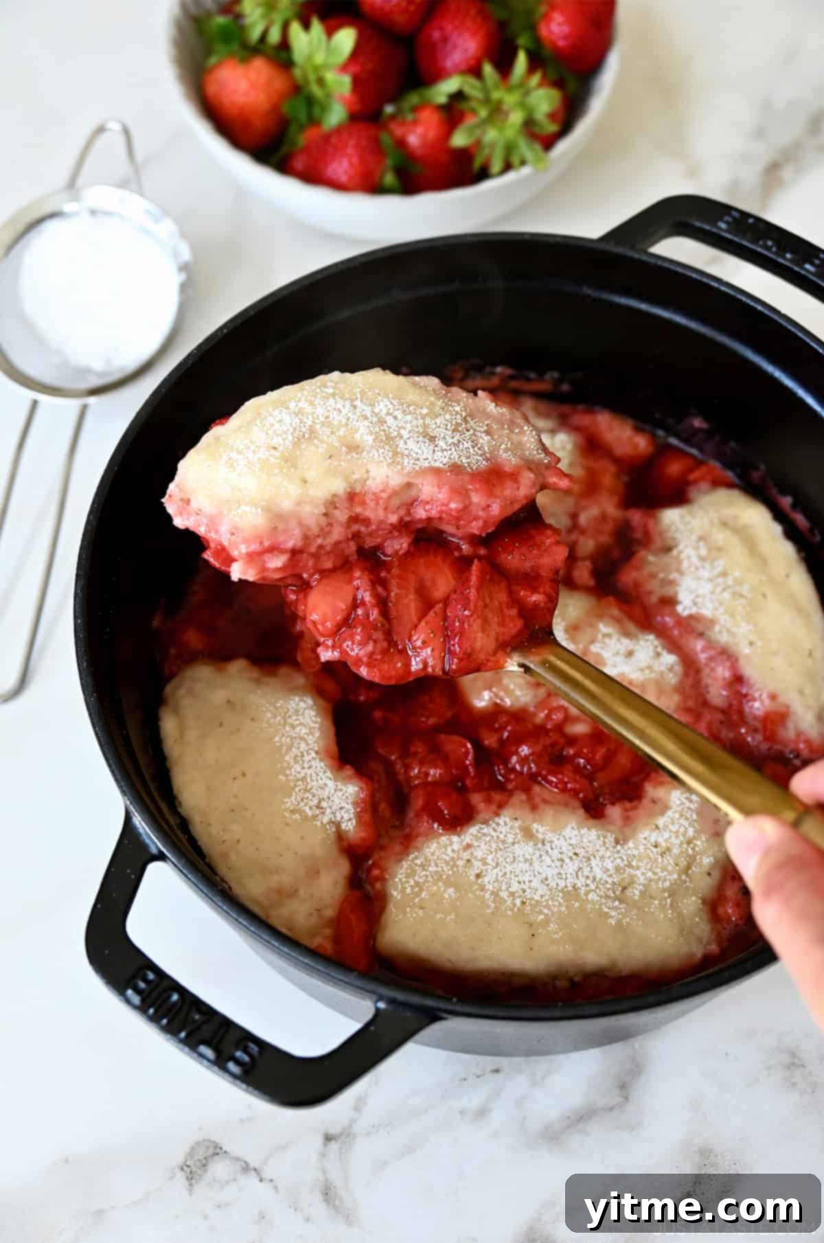 Stovetop strawberry dumplings simmering in a saucepan, a comforting and easy dessert.