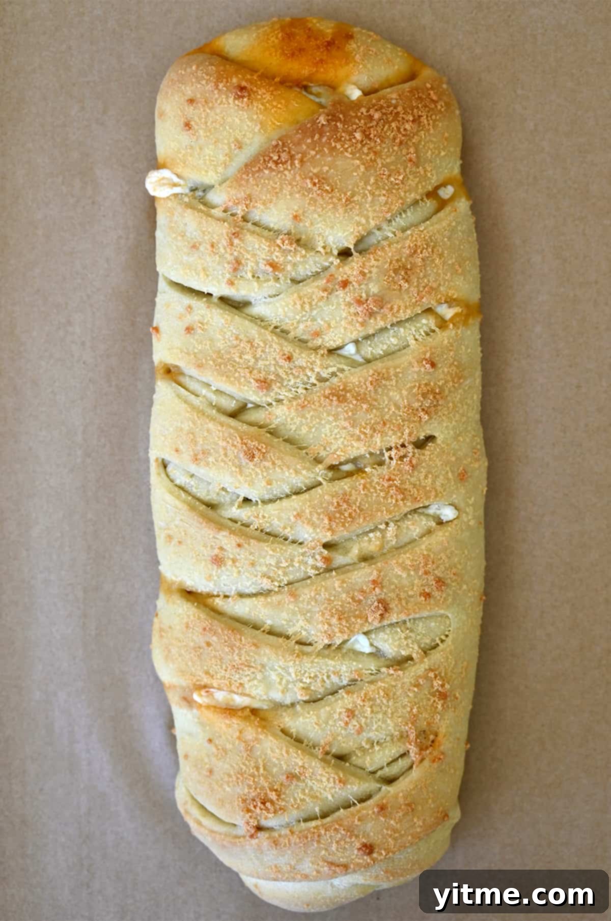 Golden brown Stromboli atop brown parchment paper.