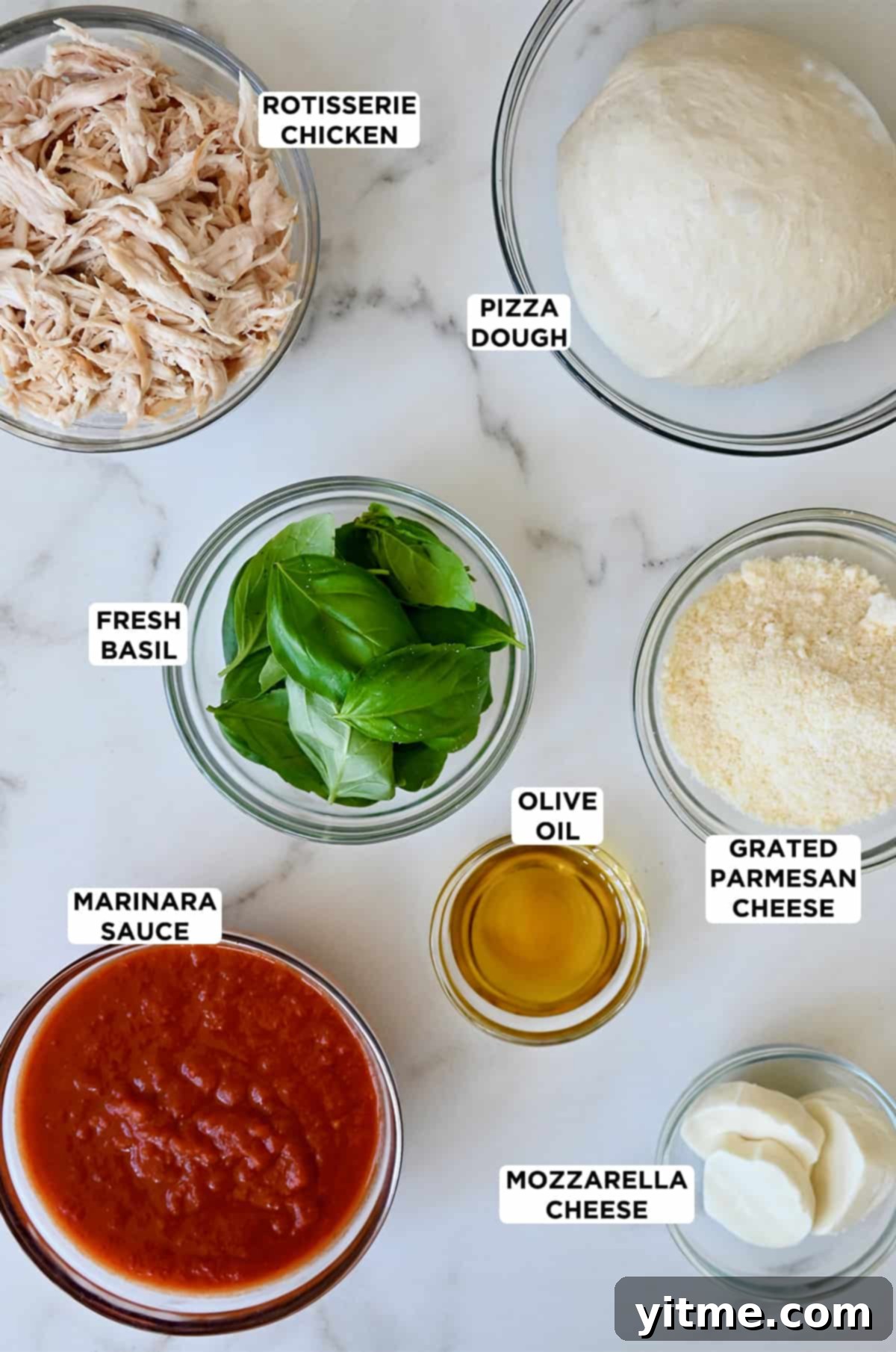 Various glass bowls displaying fresh pizza dough, shredded rotisserie chicken, vibrant fresh basil, golden olive oil, finely grated Parmesan cheese, creamy fresh mozzarella, and a rich marinara sauce, all ready for making Cheesy Chicken Stromboli.