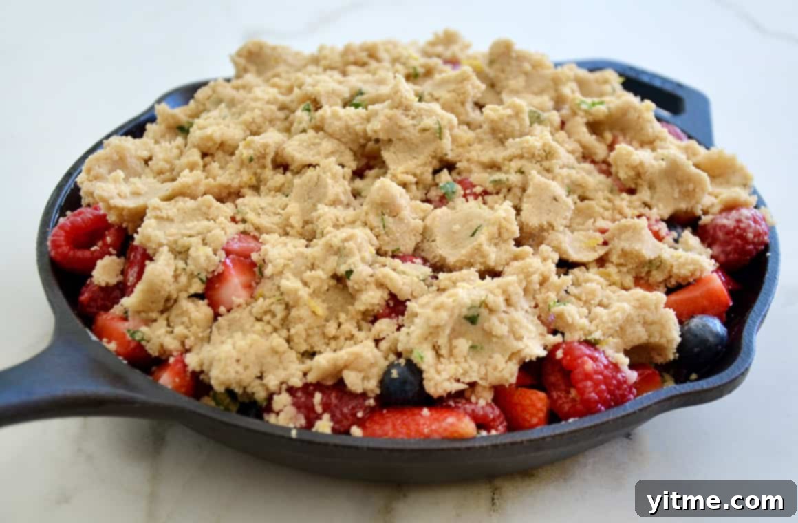 A cast-iron skillet filled with bubbly fruit crumble