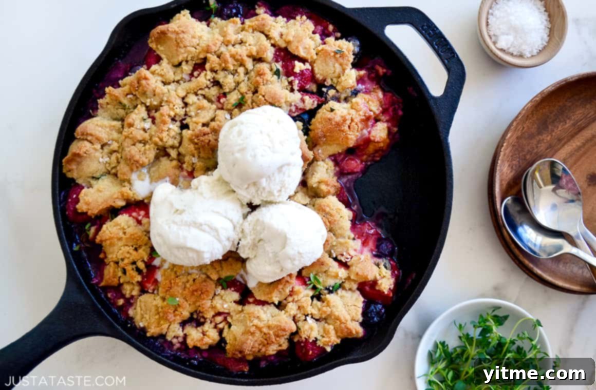 Mix-and-match fruit crumble in a cast-iron skillet, topped with melting ice cream
