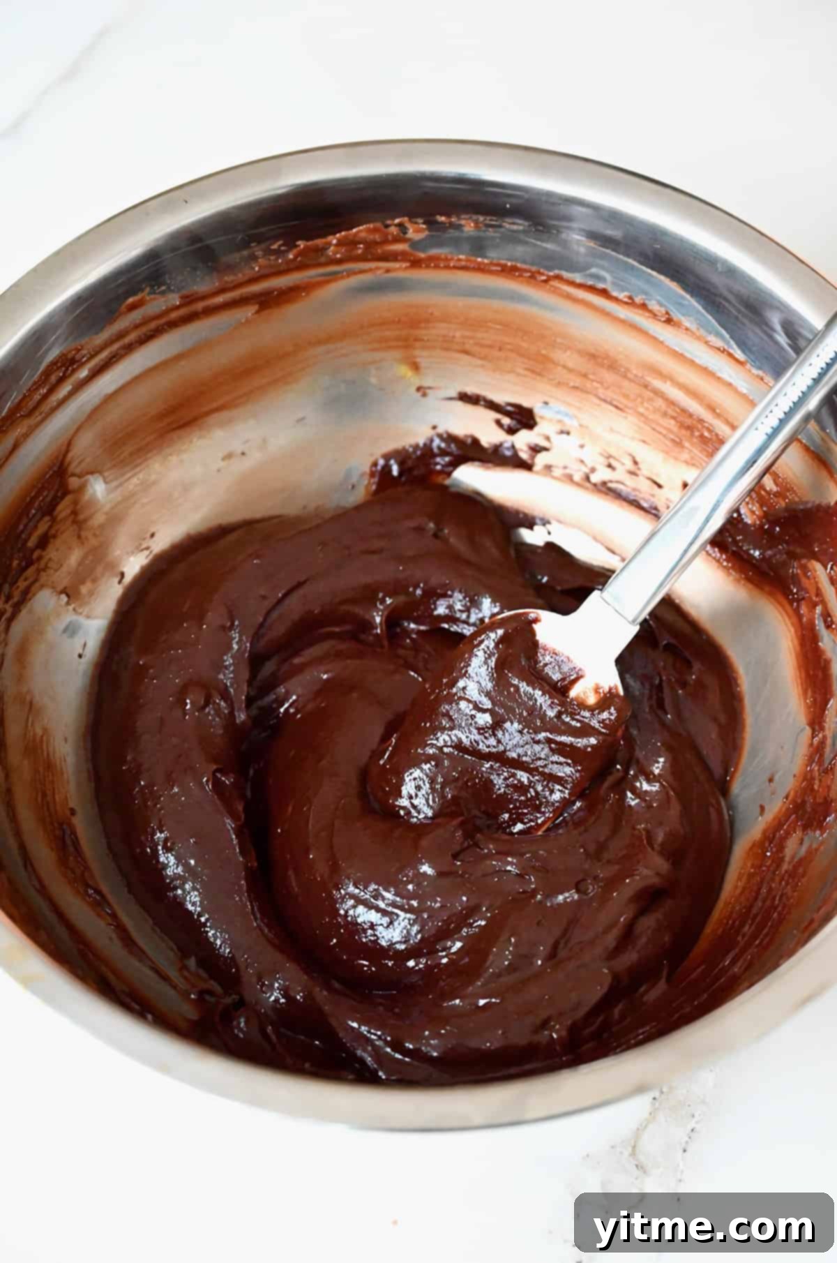 Melted chocolate mixture in a stainless steel bowl.