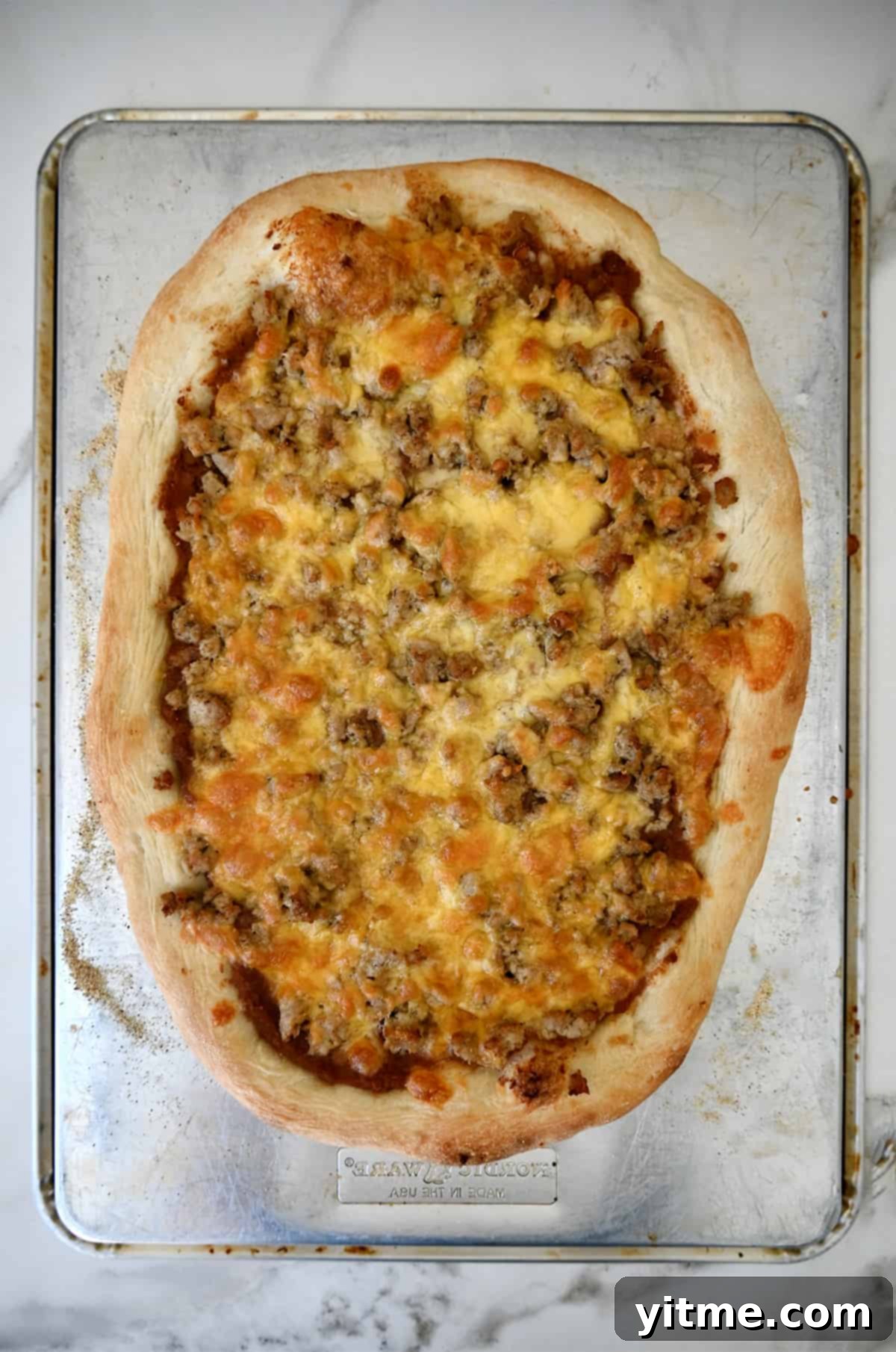 Freshly baked taco pizza without fresh toppings.