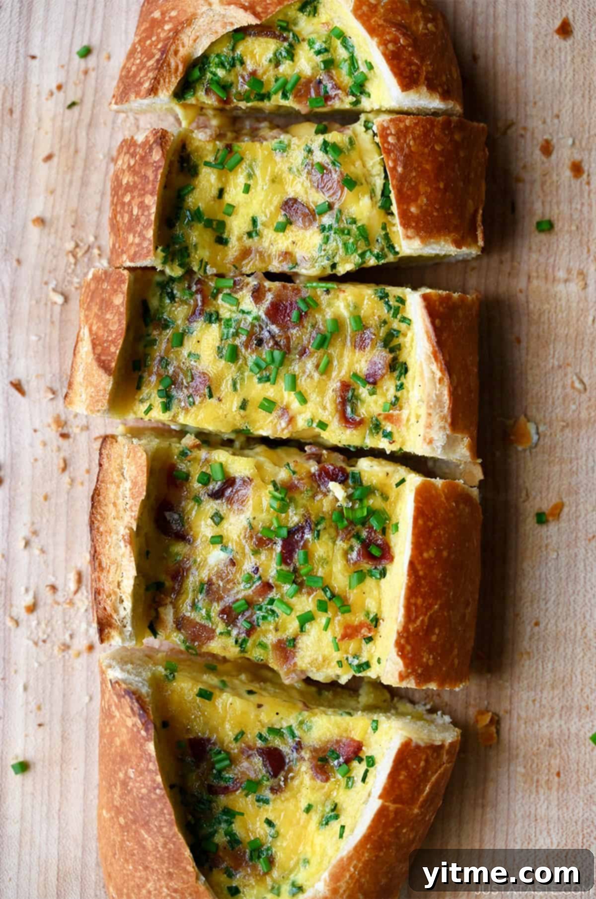 A perfectly golden-baked cheesy egg boat with crispy bacon and fresh chives, ready to be served for brunch.