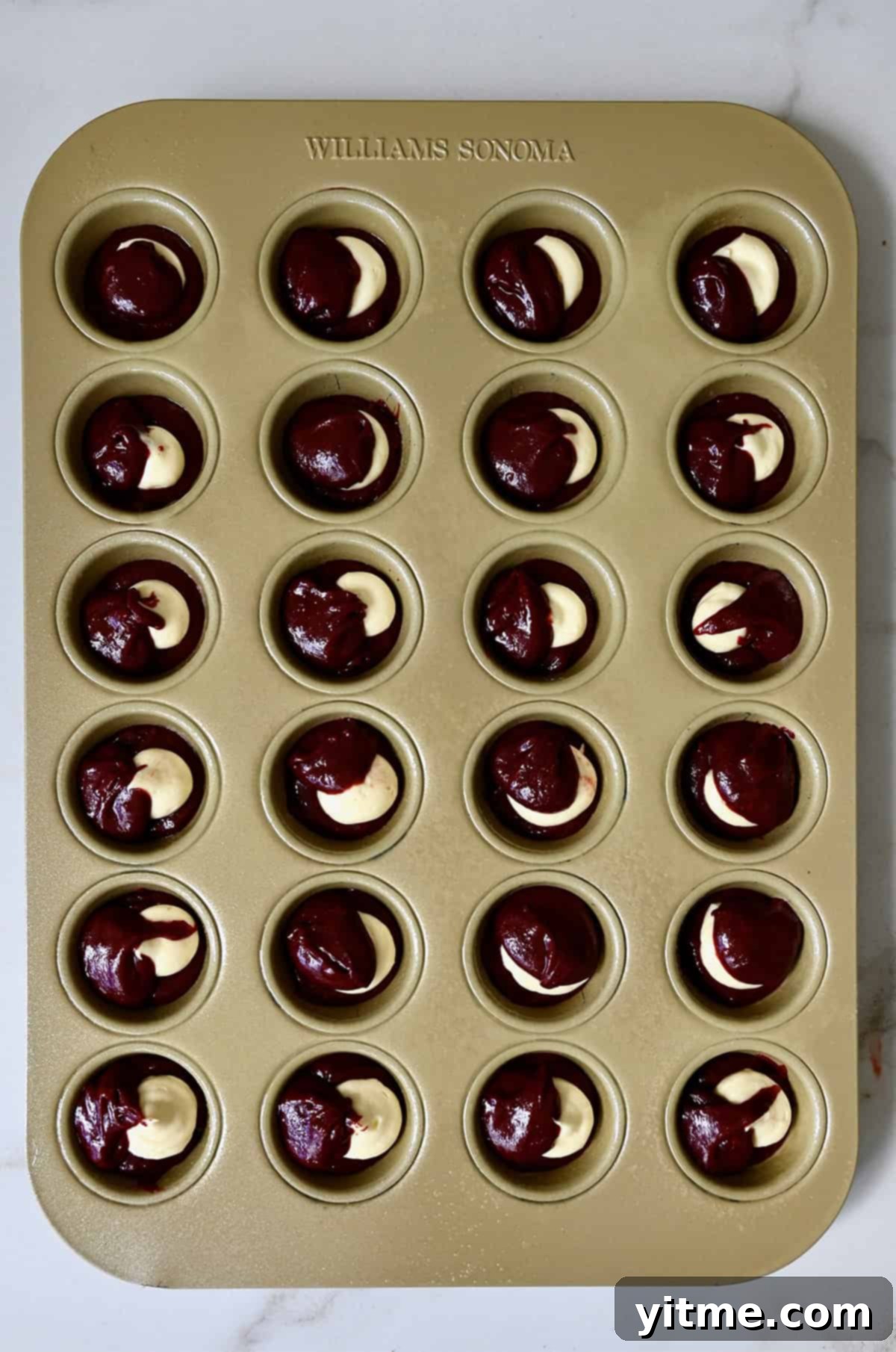 Red velvet brownie bites with a cheesecake center before baking.