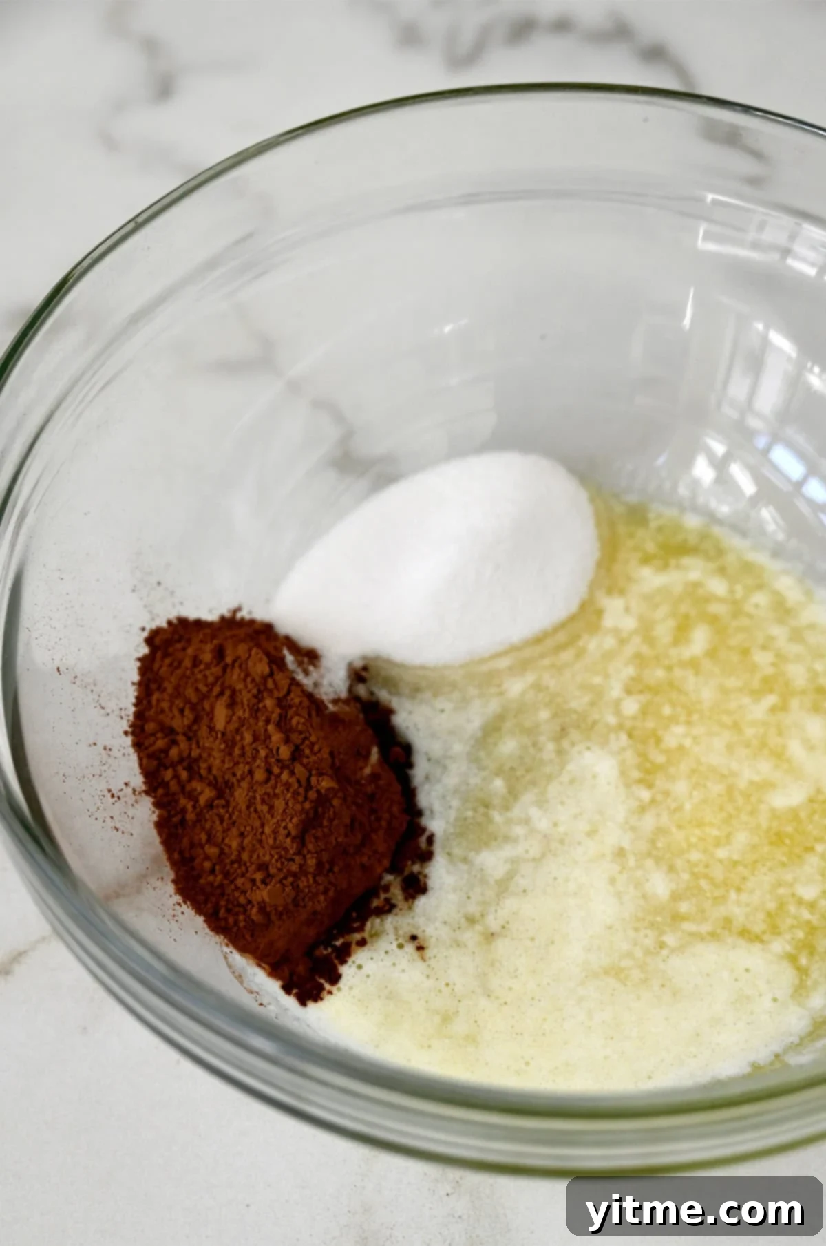 Dry ingredients for red velvet brownie batter in a glass bowl.
