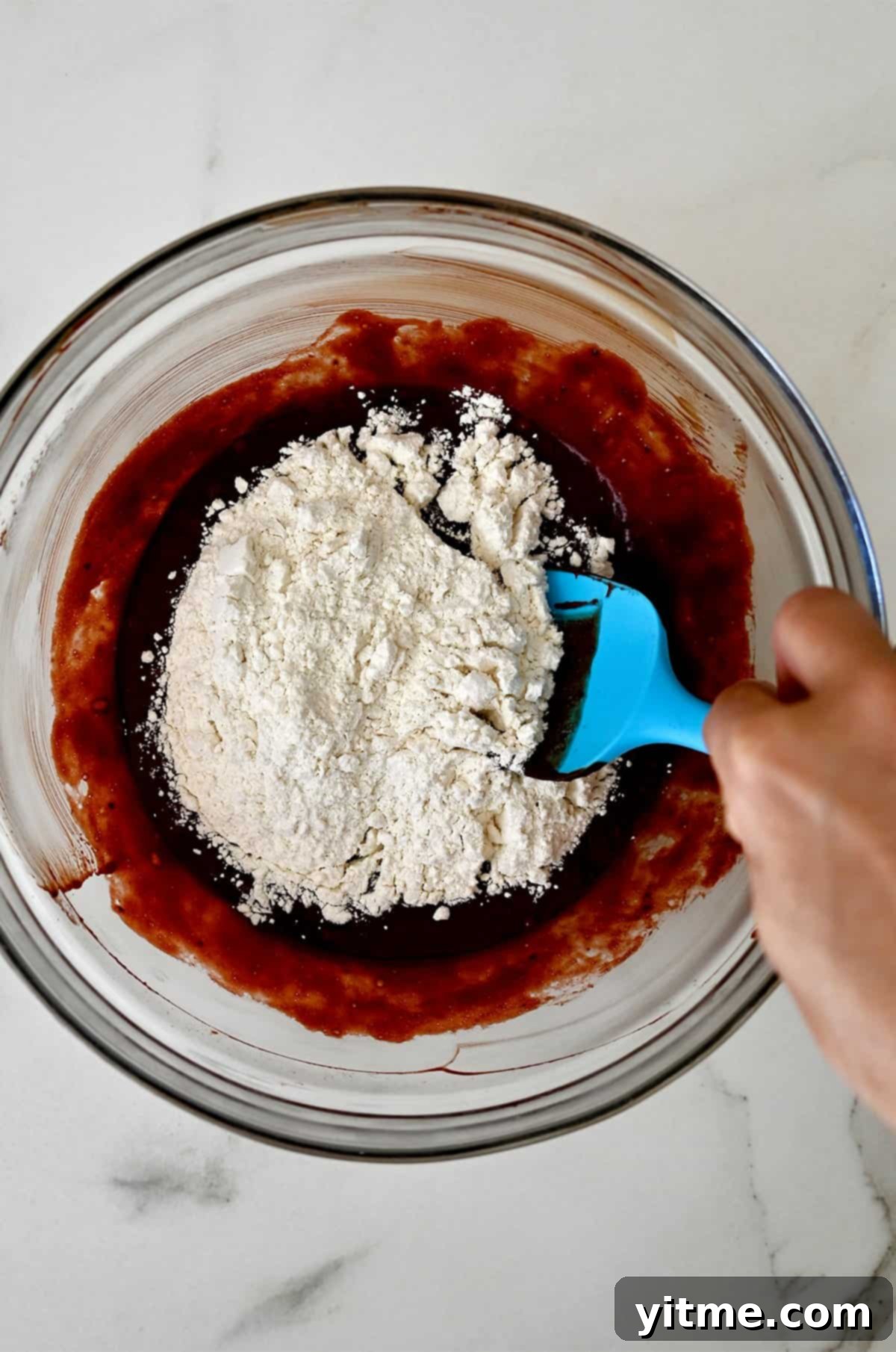 Adding flour to make a red velvet brownie mix.