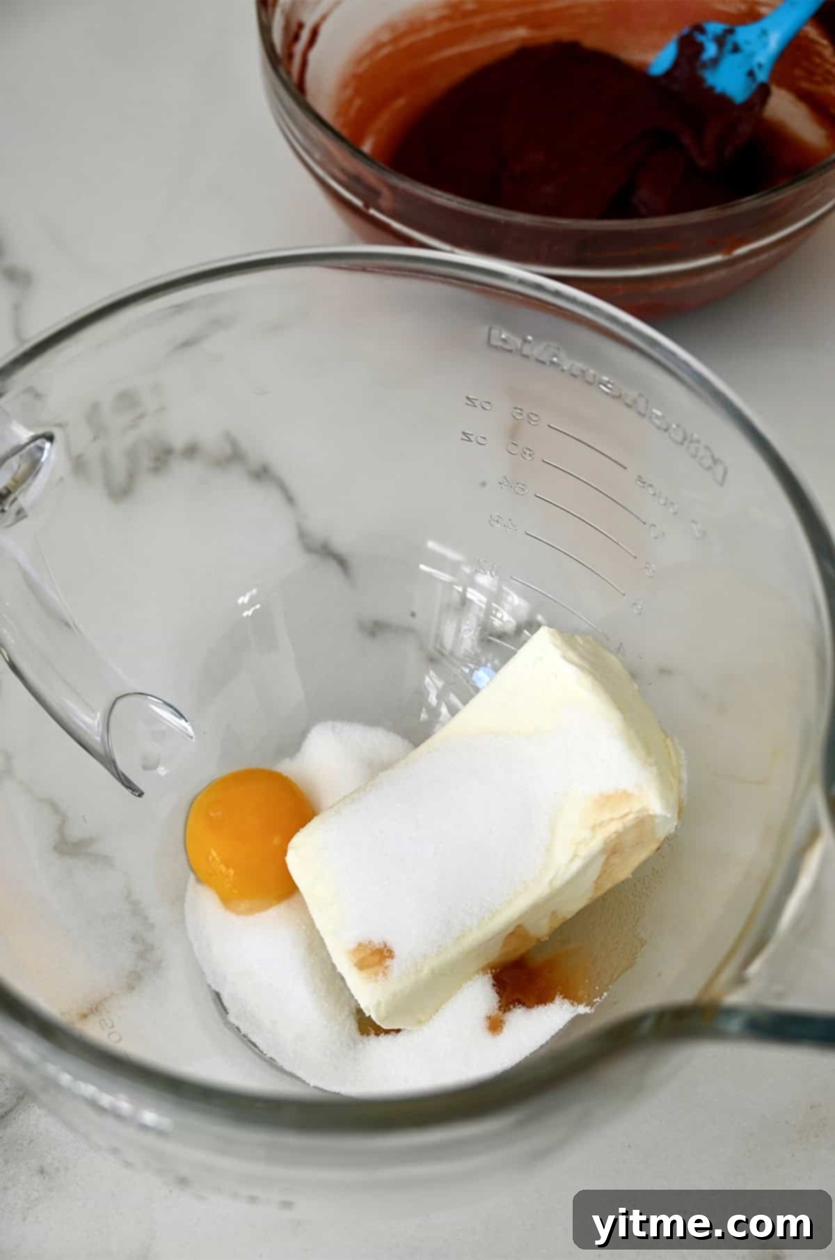 Cream cheese, egg yolk, sugar and vanilla in a bowl.