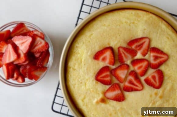 The baked Strawberry Cream Cheese Coffee Cake with fresh strawberries cooling on a wire rack.