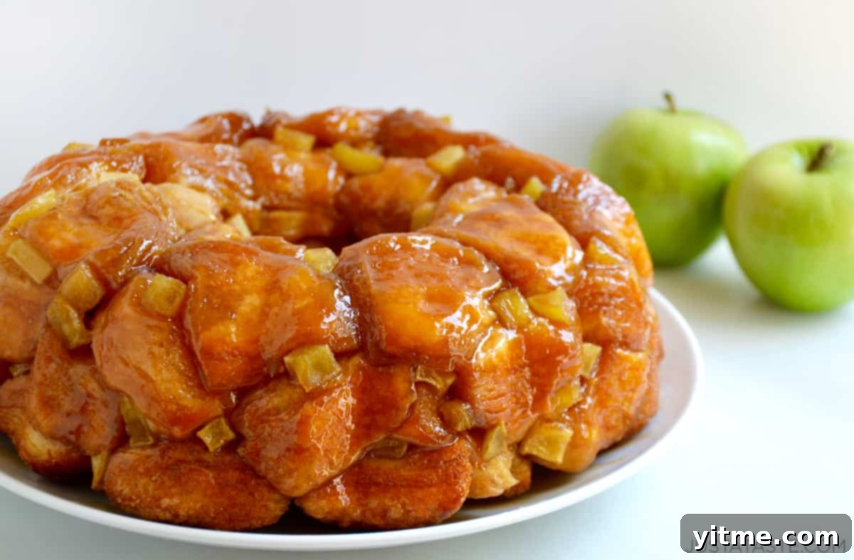 An enticing image of Caramel Apple Monkey Bread with diced apples, plated on a pristine white serving dish.