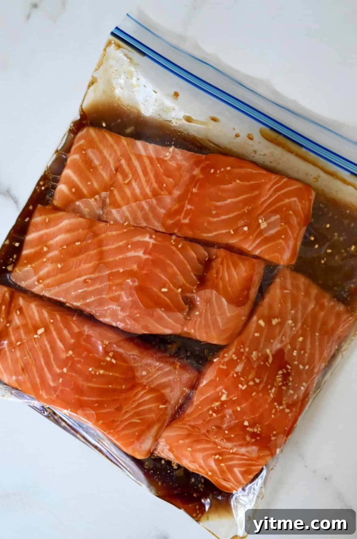 Honey-Garlic Glazed Salmon Delight 5 Salmon marinating in a plastic ziplock bag.