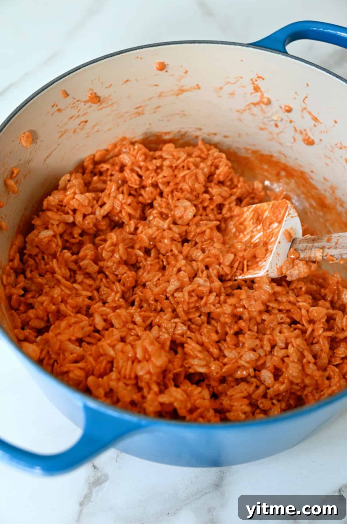 Pumpkin Spice Rice Krispies Delights 5 Orange-colored Rice Krispies mixture in a large stockpot.