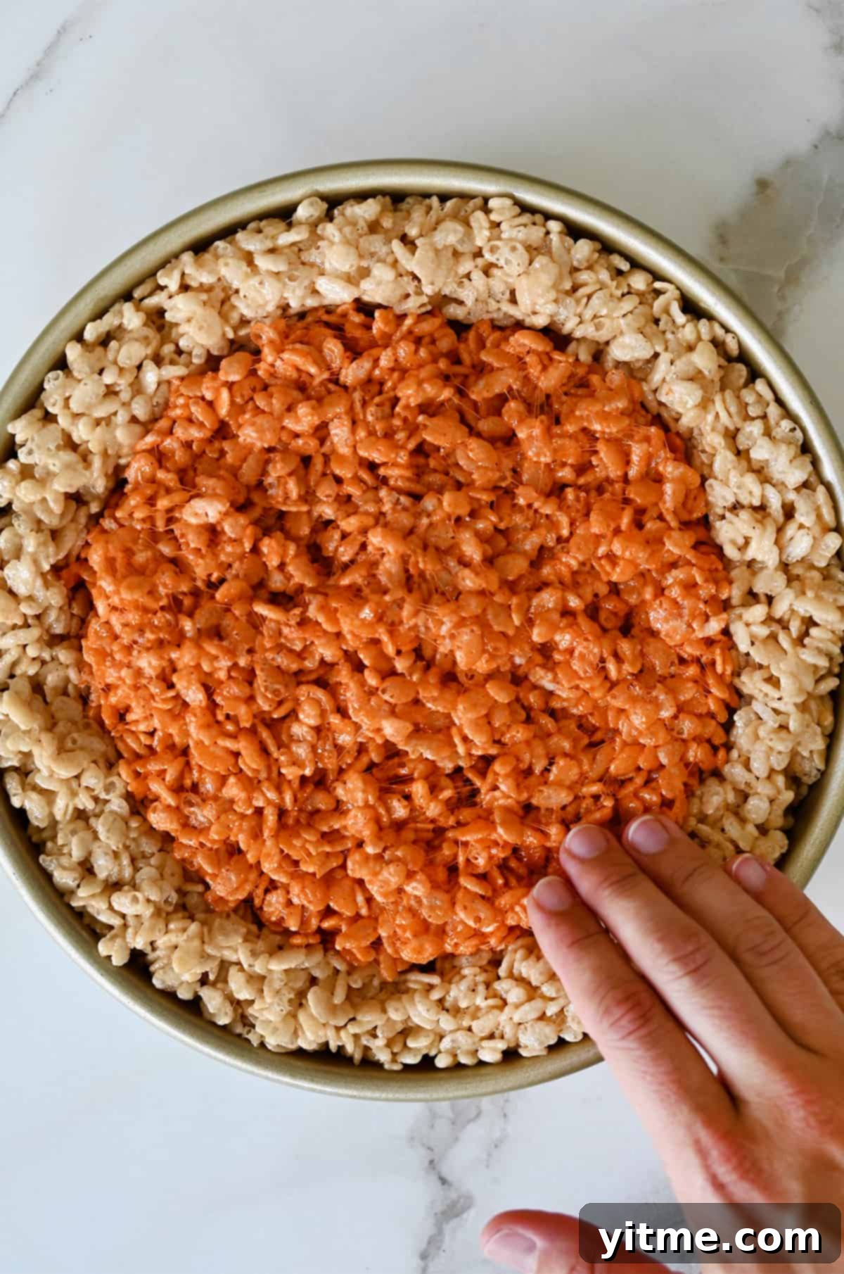 Pumpkin Spice Rice Krispies Delights 6 Pressing the pumpkin marshmallow treats into the center of a round cake pan.