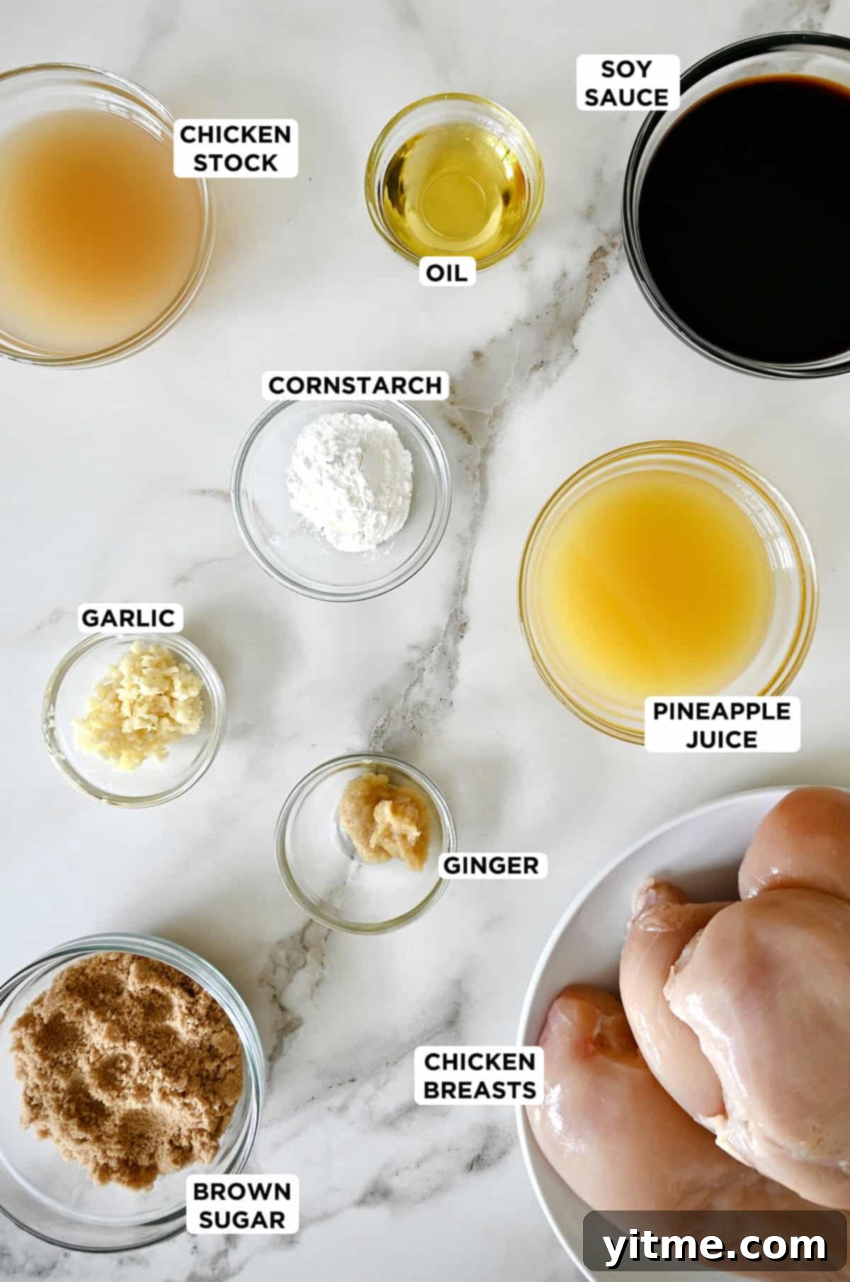 Chicken breasts on a plate next to glass bowls containing teriyaki sauce ingredients.