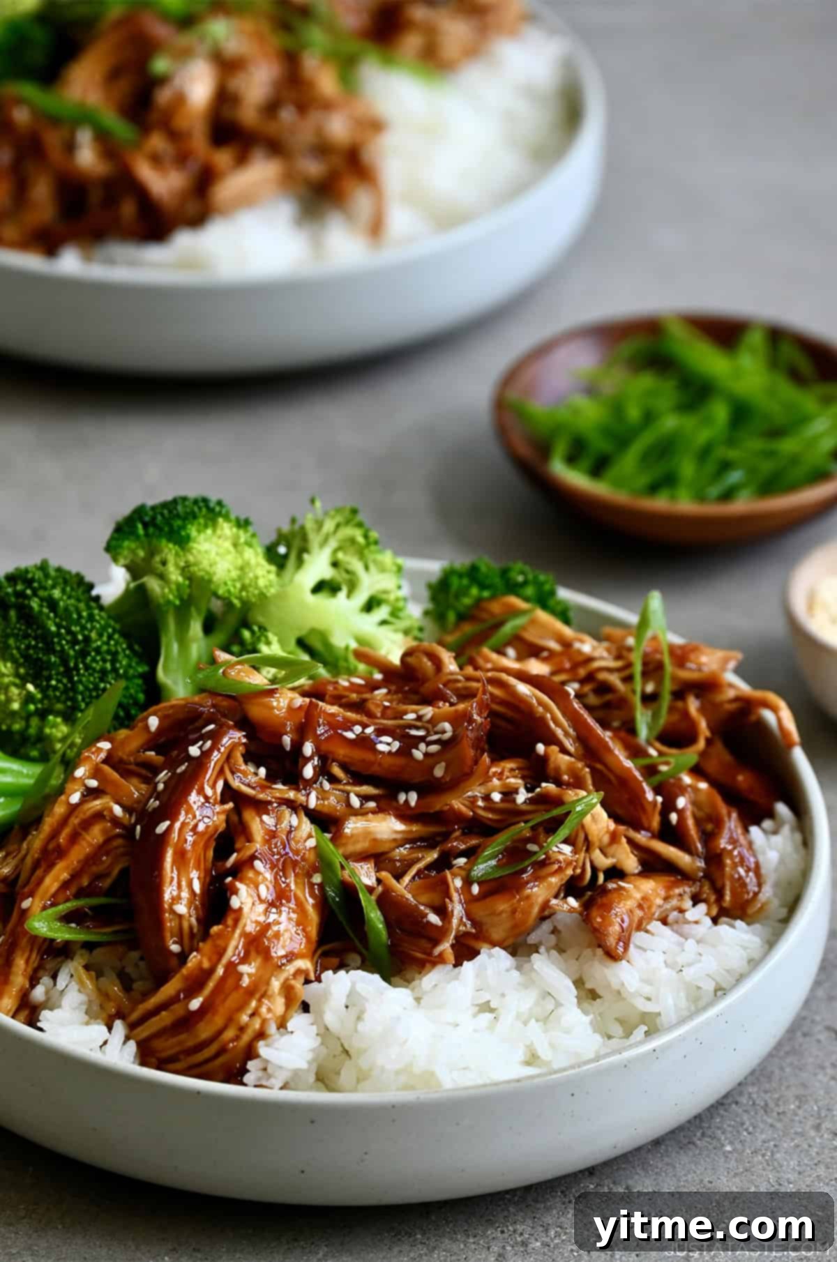 Slow cooker chicken teriyaki with jasmine rice and steamed broccoli in a bowl.