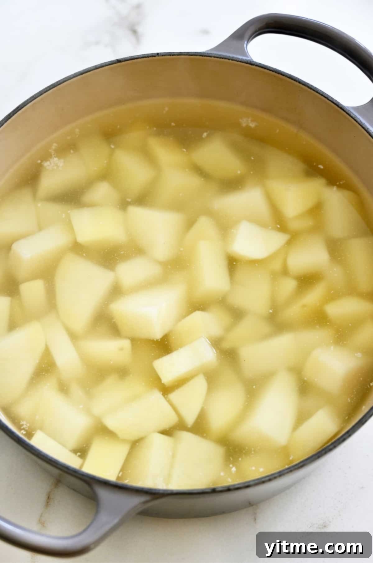 Ultimate Creamy Dream: The Mashed Potato Revelation 4 Boiling potatoes in a large stockpot.
