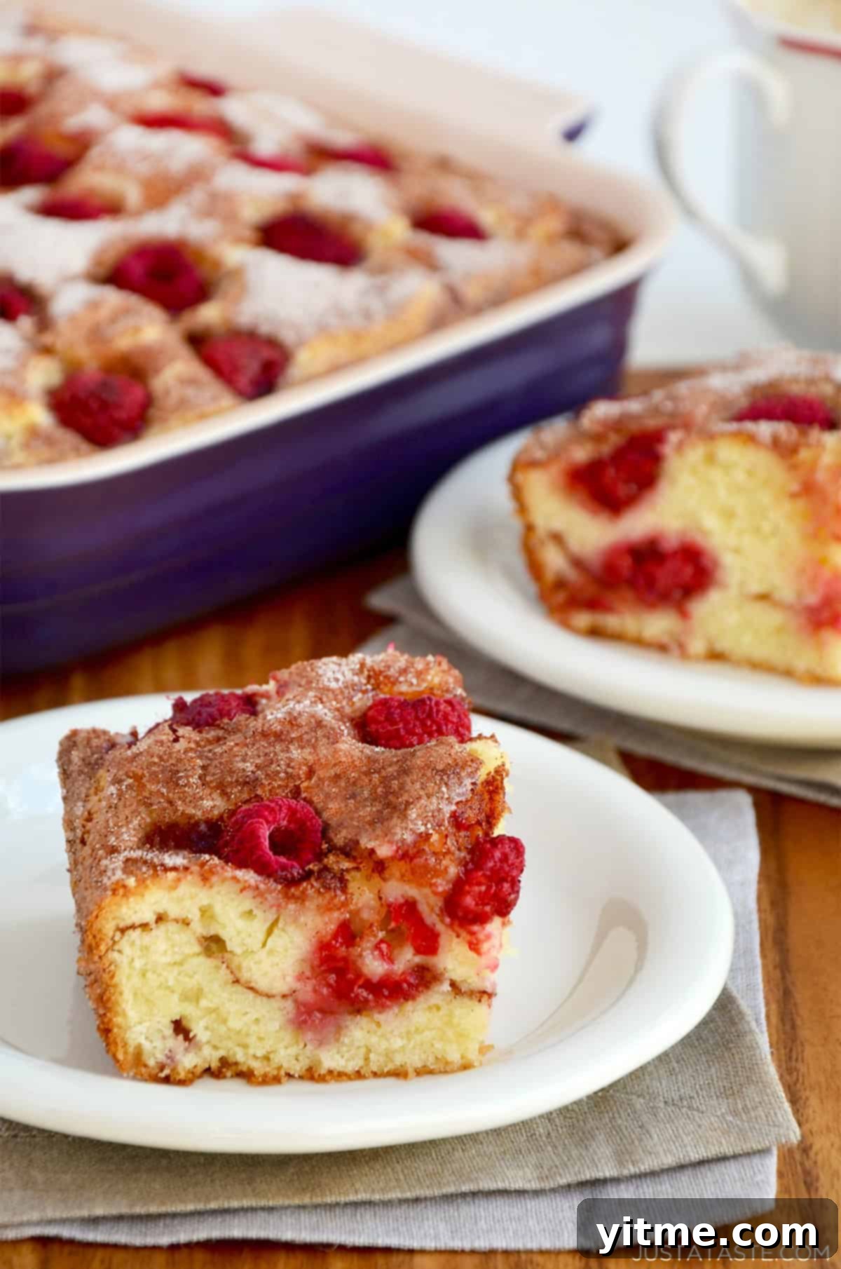 Raspberry sour cream coffee cake on a small white plate.