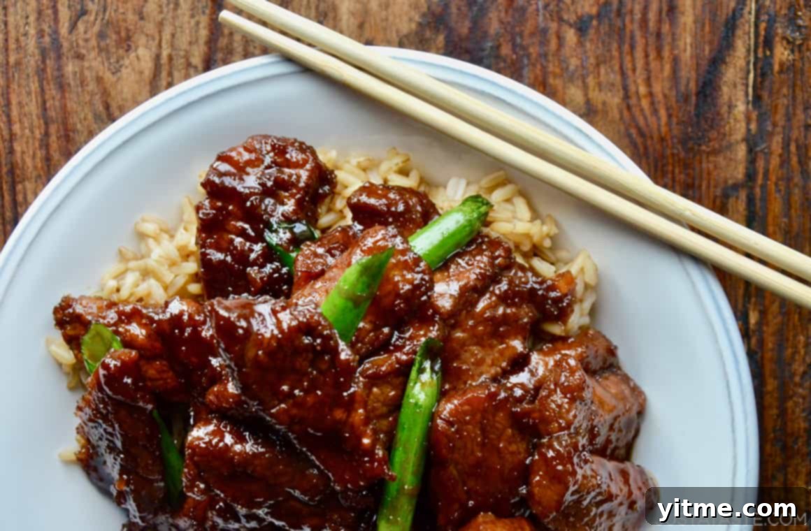Delicious Mongolian beef over brown rice, garnished with scallions.
