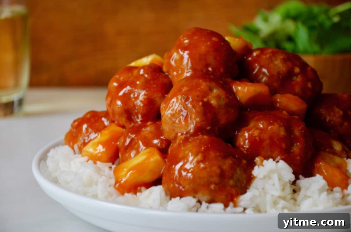 Sweet and sour meatballs with pineapple chunks served over rice.