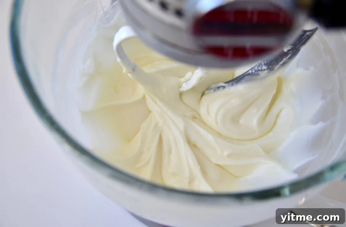 Cream cheese glaze being mixed in a stand mixer