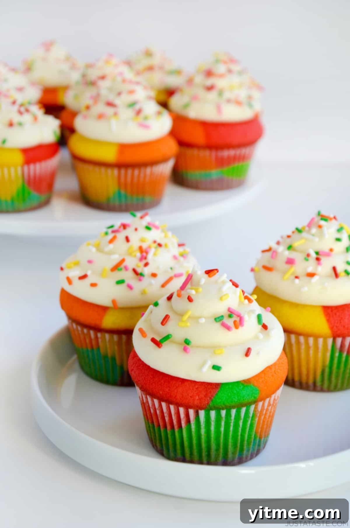 Rainbow Cupcakes with Buttercream Frosting and sprinkles on white plate