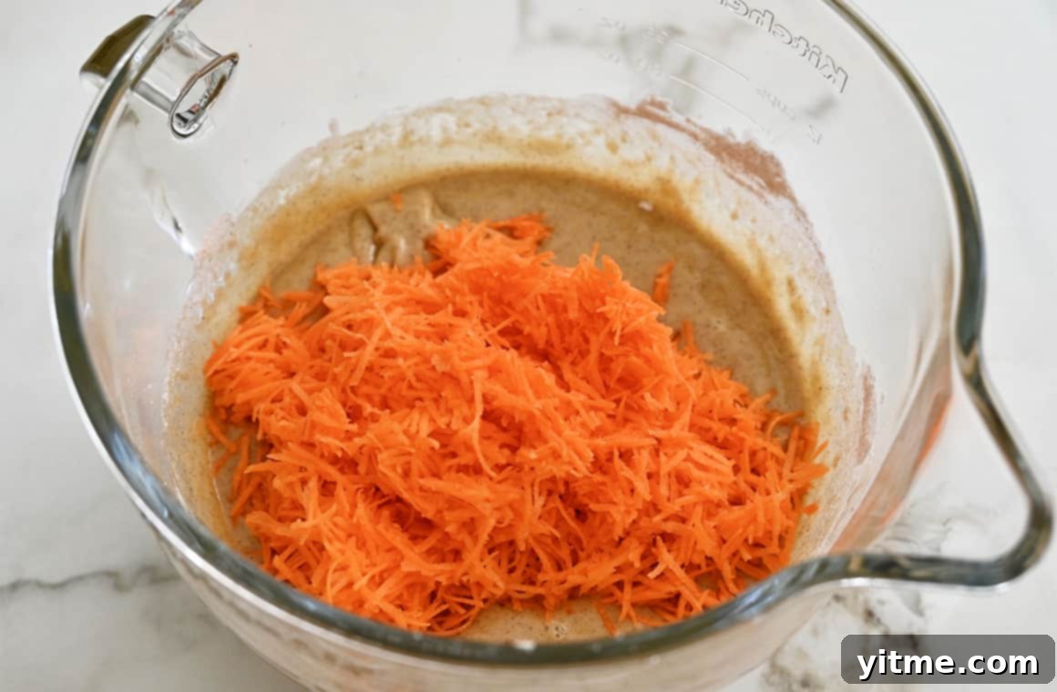 Shredded carrots being added to cake batter