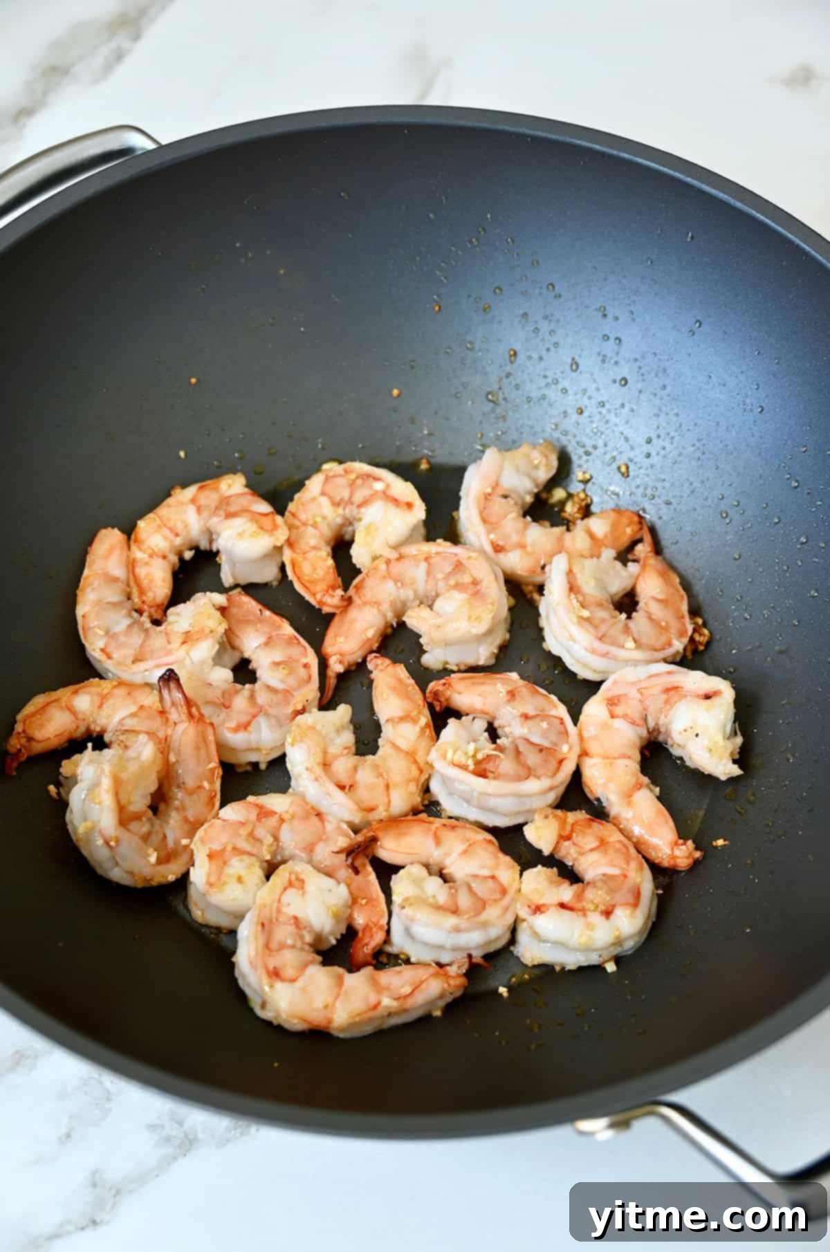 Sautéed shrimp and garlic in a wok.