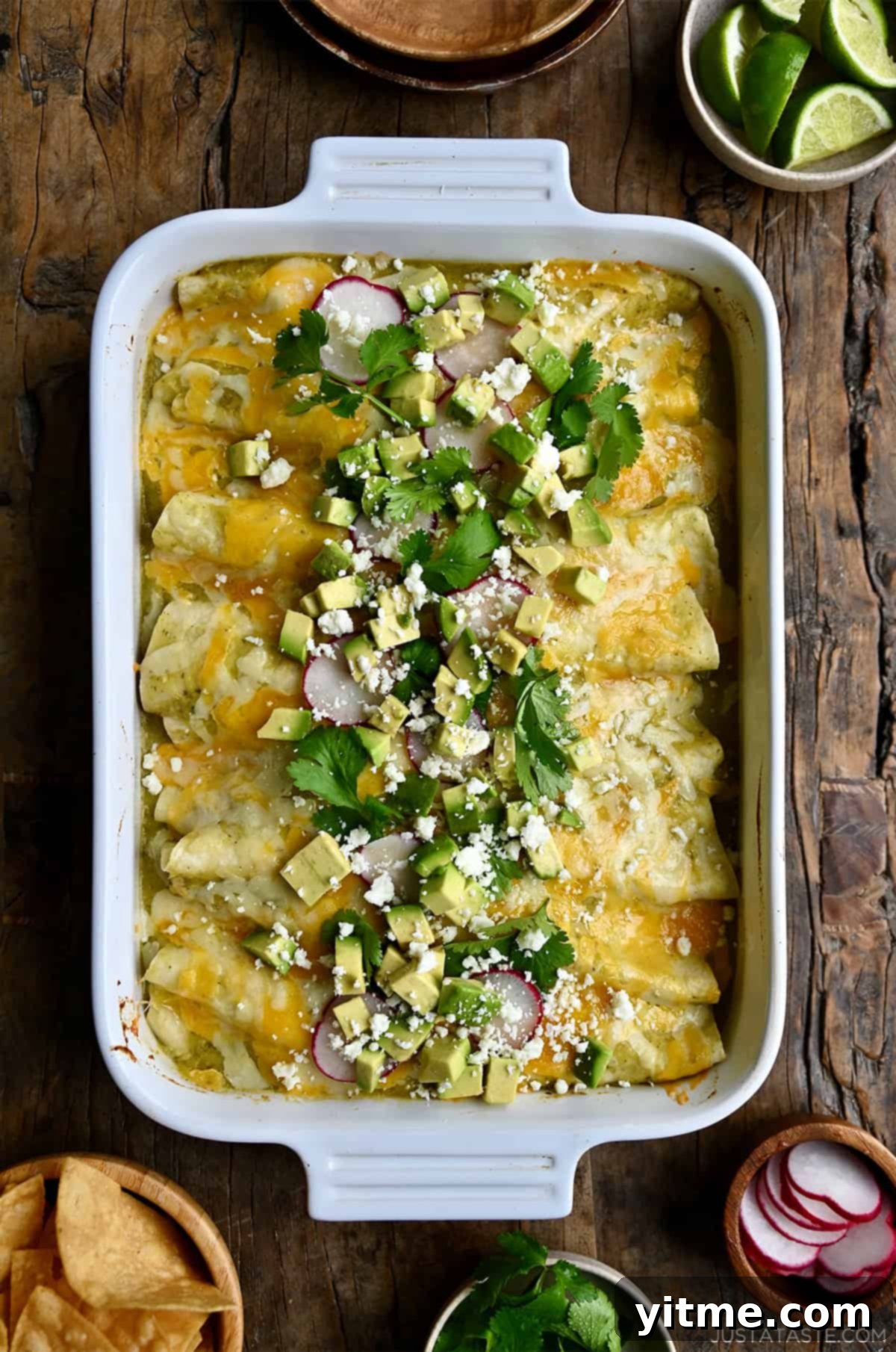 Salsa verde enchiladas topped with avocado, radishes, cilantro and crumbled Cojita cheese.
