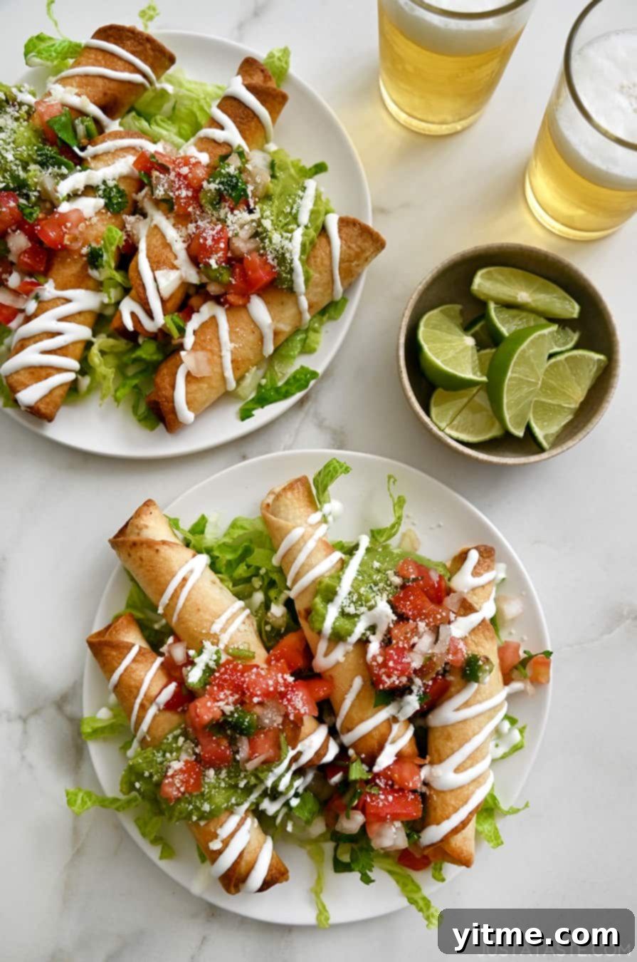 Two plates of golden-brown baked cheese taquitos adorned with fresh pico de gallo and creamy guacamole, nestled atop a bed of crisp lettuce, alongside a small bowl of vibrant lime slices.
