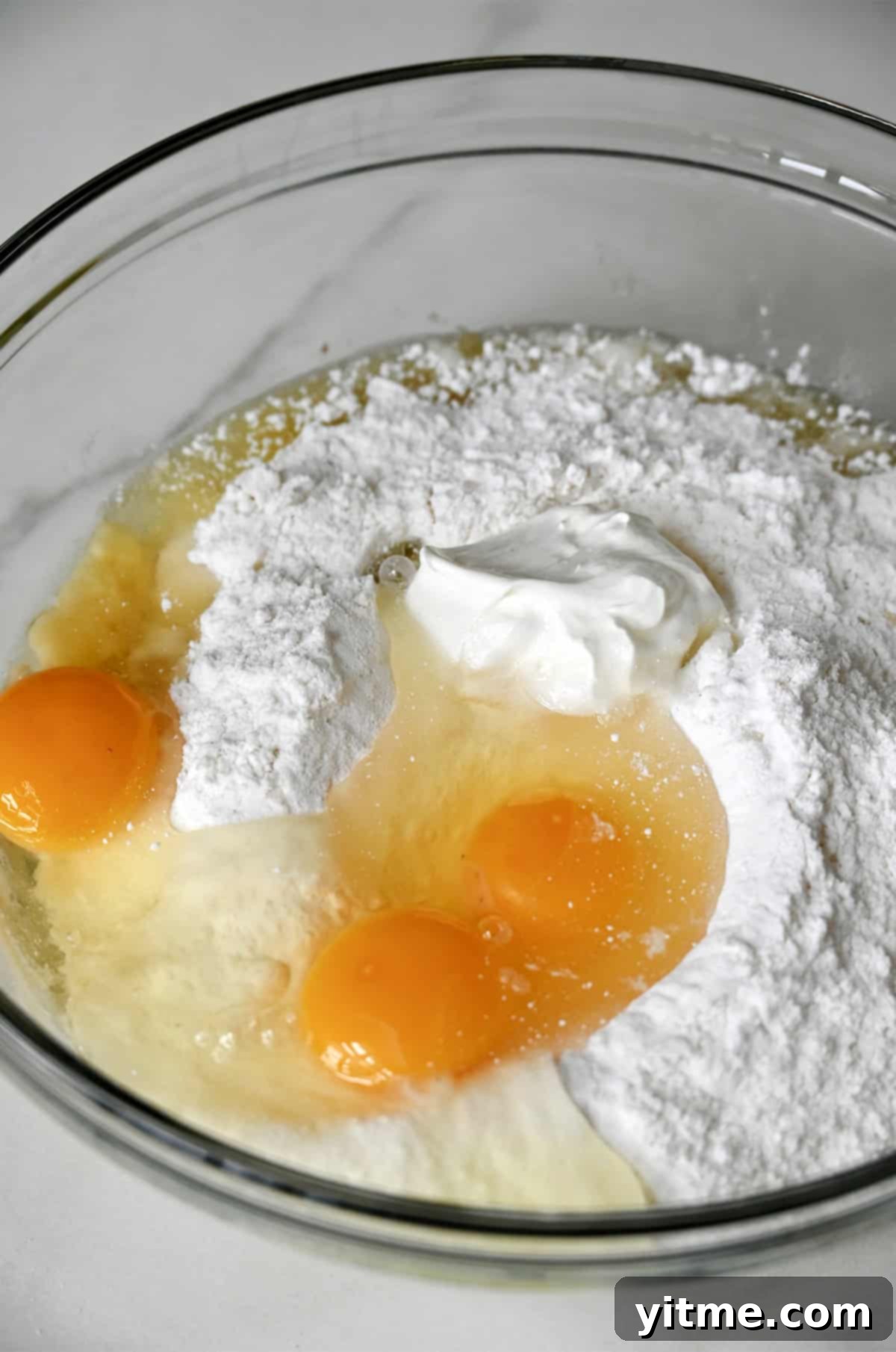 Cake mix, eggs, oil, and sour cream in a bowl
