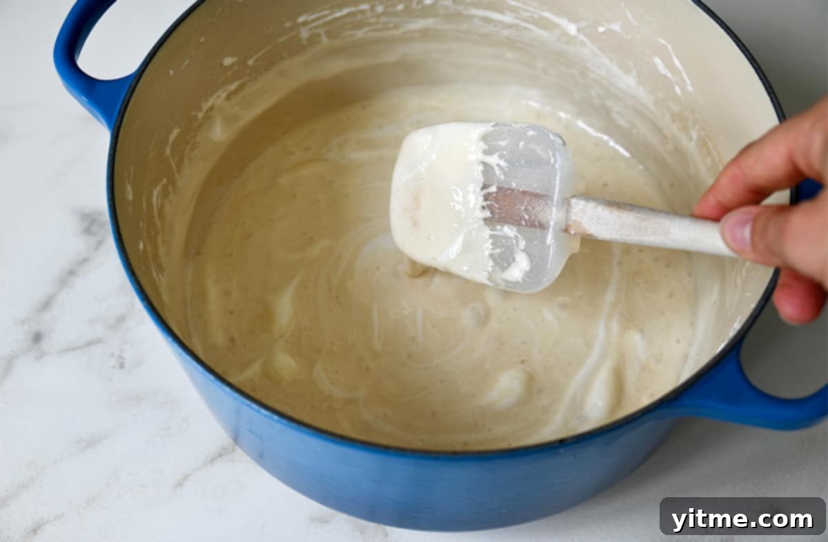 Peanut Butter Cheerios Marshmallow Bars 4 A spatula stirring perfectly melted marshmallows and butter in a large stockpot, ready for the next ingredients.