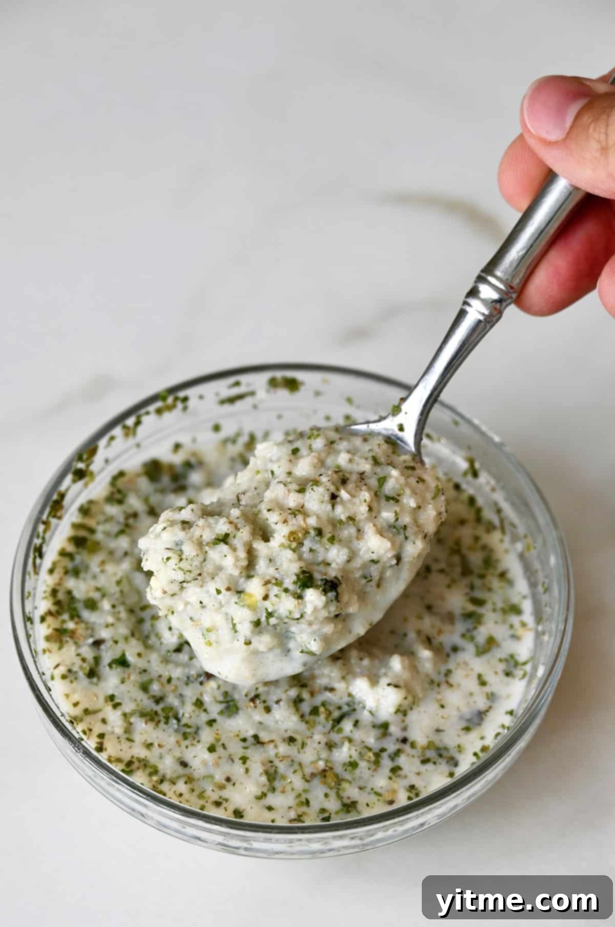 A small bowl holding the herb breadcrumb panade, a mixture of Italian breadcrumbs soaked in milk, ready to be added to the meatloaf for extra moisture.