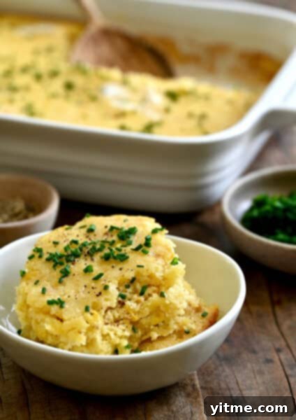 A scoop of creamy corn casserole with chives.